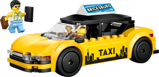 Yellow LEGO taxi car with NYC skyline, featuring a mini-figure in casual attire and briefcase.